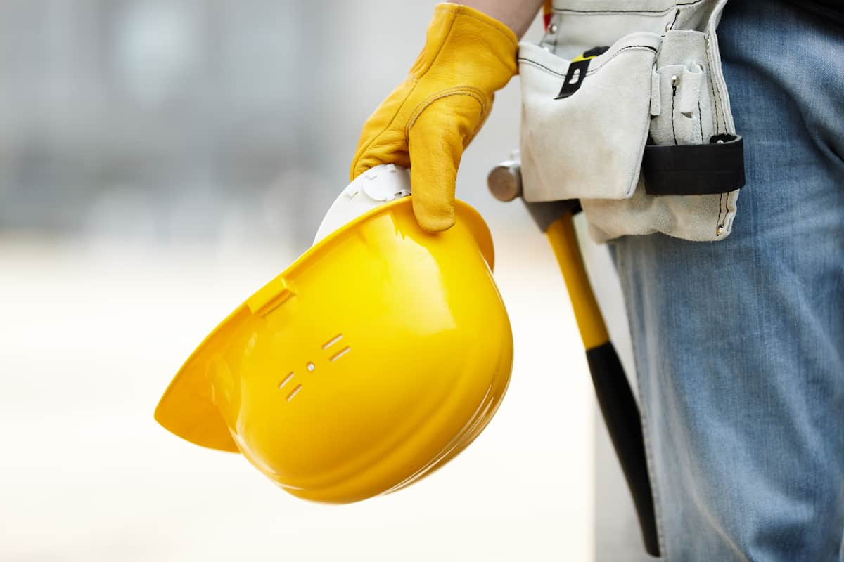 Tradesman with yellow hard hat standing